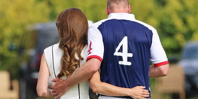 Kate Middleton and Prince William with their backs turned from the camera as they embrace each other