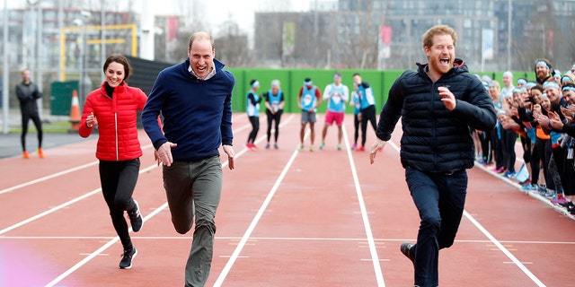 Prince Harry smiling as he runs in a race with Prince William and Kate Middleton