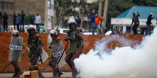 Riot police fire tear gas grenades