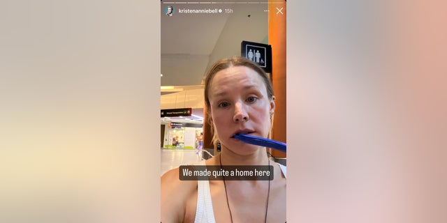 Kristen Bell has a toothbrush in her mouth as she walks through the airport with the caption "we made quite a home here"