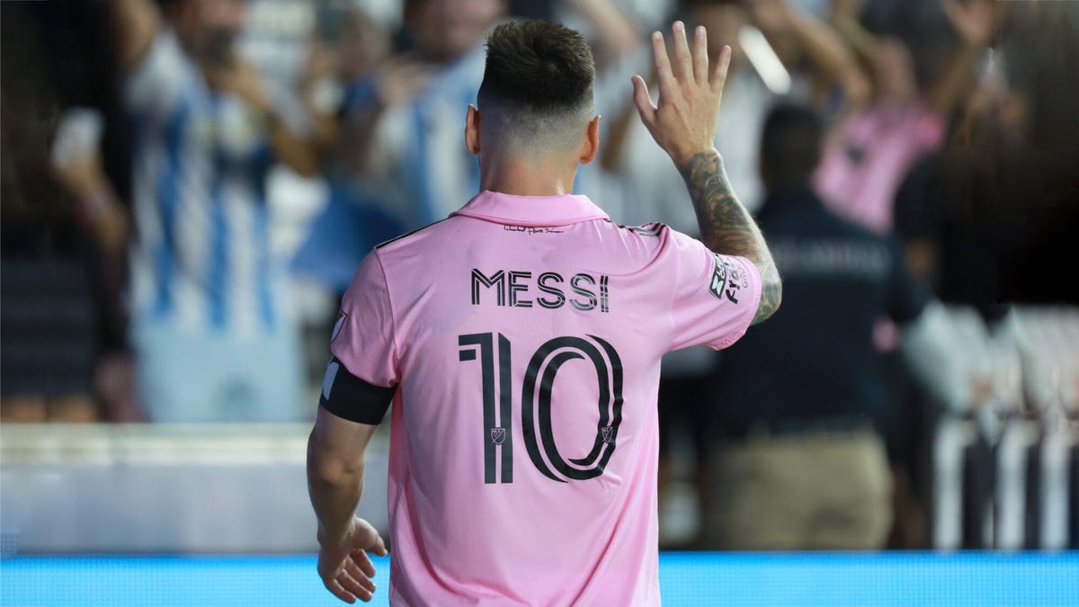 Inter Milan forward Lionel Messi waving at fans with his back to camera, wearing an Inter Miami shirt with his surname and number 10 printed on the back.