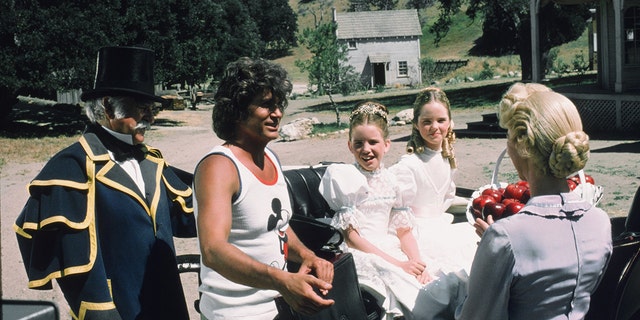 Michael Landon in a Mickey Mouse tank top directing his castmates in costume