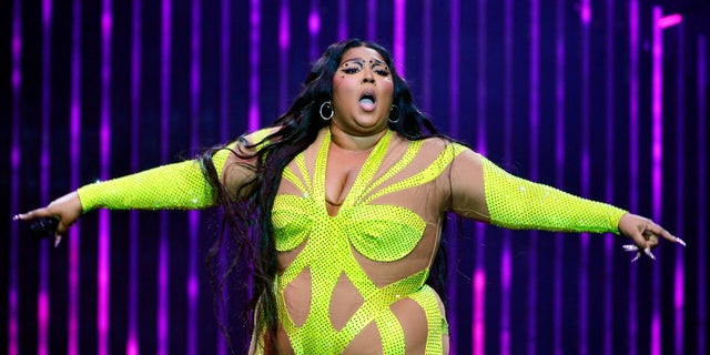 Lizzo in yellow spandex outfit performing on stage