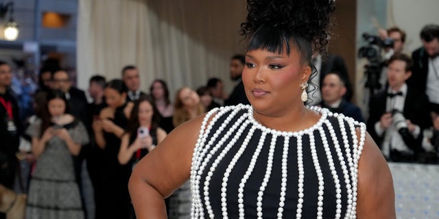 Lizzo in a black and white dress with her hair up at the Met Gala