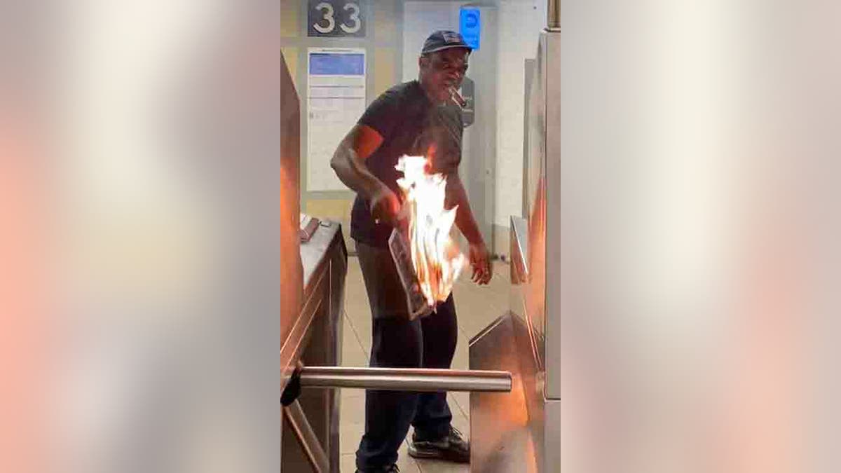 man lighting newspapers on fire