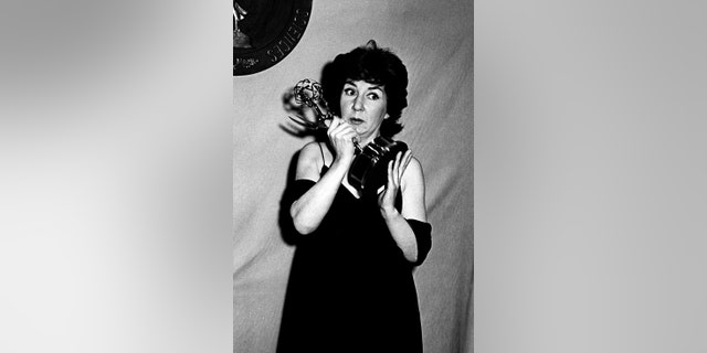 Maureen Stapleton holding her Emmy and looking surprised
