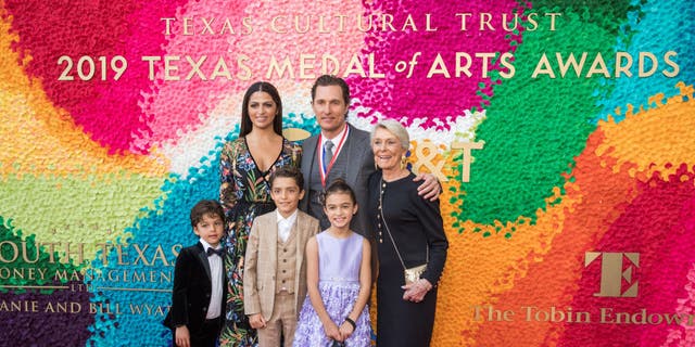 Matthew McConaughey poses with his family Camila in a long dress, his mother Kay and three children on the red carpet