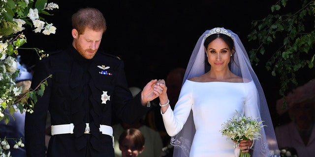 Prince Harry holding Meghan Markle's hand on their wedding day