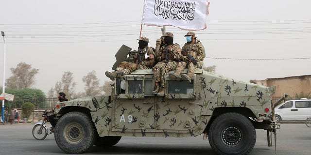 Taliban fighters on vehicle in Afghanistan