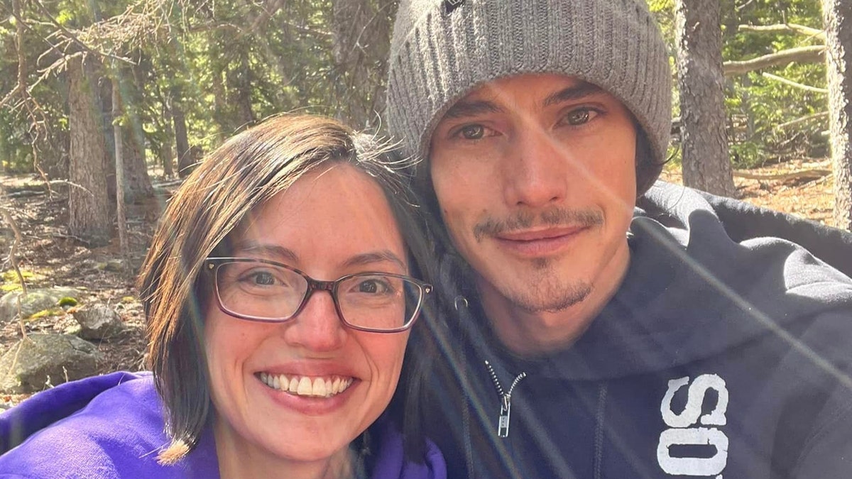 Joslyn Teetzel and Miles Kirby smile in a selfie taken in the woods near Colorado Springs