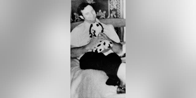 Dean Allen Corll sits on a bed