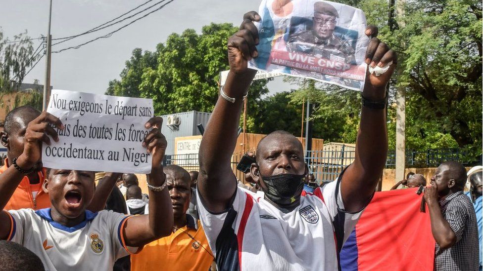A supporter holds a picture of Niger General Abdourahamane Tiani, the chief of the powerful presidential guard, as with others rally in support of Niger's junta in Niamey on July 30, 2023