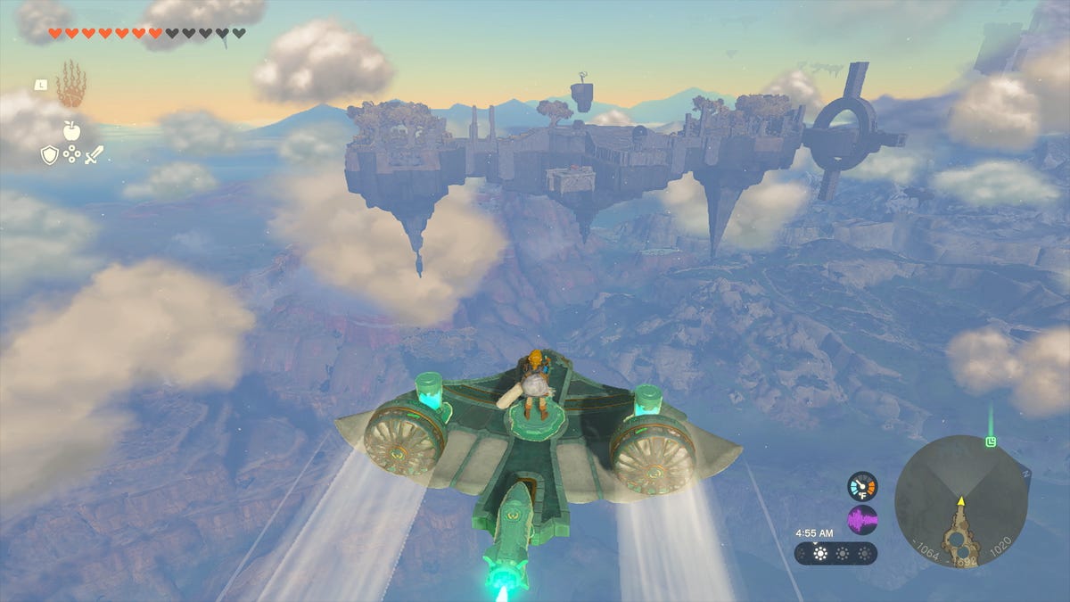 A boy on a gliding hovercraft over cloud-filled skies, far above the ground in a screenshot of Nintendo's Zelda Tears of the Kingdom game
