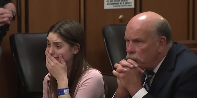 Ohio woman weeps and covers mouth in courtroom.