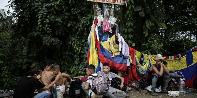 migrants sitting at panama, colombia border