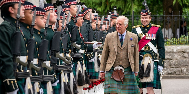 King Charles in a traditional Scottish uniform inspecting his guards