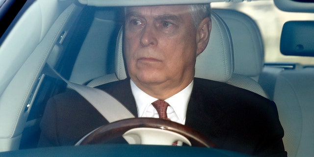 A close-up of Prince Andrew driving in a suit