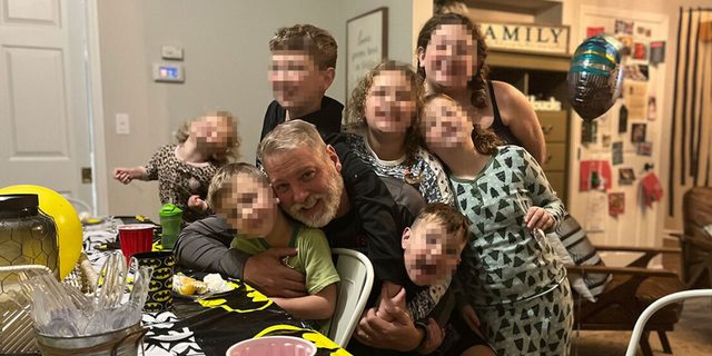 Mark Houck seen smiling while surrounded by his children