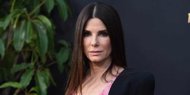 Sandra Bullock in a pink dress and black jacket at "The Lost City" premiere