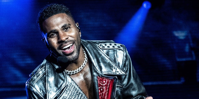 Jason DeRulo sings on stage in Denmark with a silver chain necklace and a black leather jacket