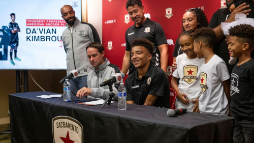 Da'vian Kimbrough, 13, is surrounded by his family and team management after signing contract with the Sacramento Republic of the second-tier League Championship of the United Soccer League, Tuesday, Aug. 8, 2023,  in Sacramento, Calif. (Paul Kitagaki Jr./The Sacramento Bee via AP)