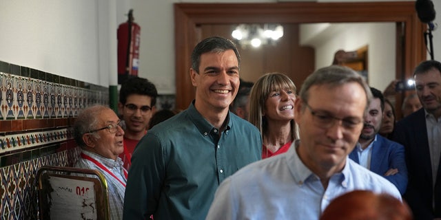 Spains Prime Minister Pedro Sanchez smiles for cameras upon arriving to the polling station