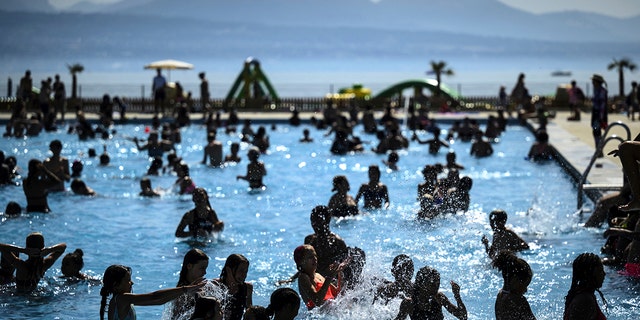 People cool off in the water during hot weather