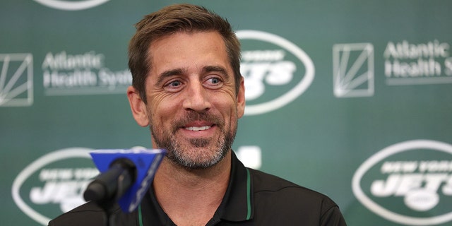 Aaron Rodgers behind the podium as he is announced as the New York Jets newest QB