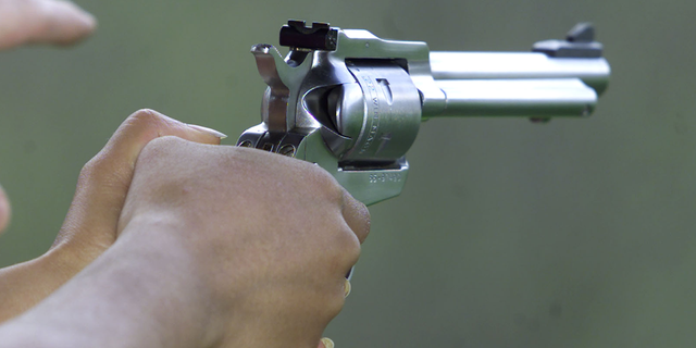 hands grasping handgun closeup shot