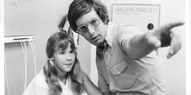 Black and white photo of young Linda Blair being directed by William Friedkin