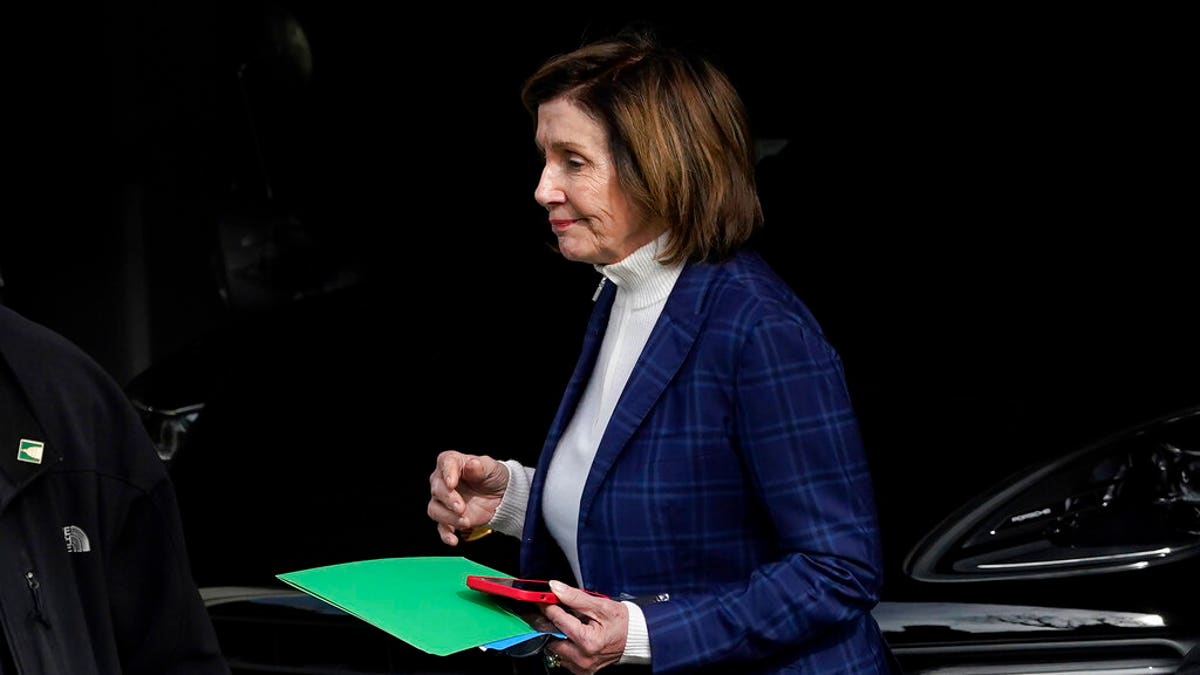Nancy Pelosi leaves her garage holding green folder