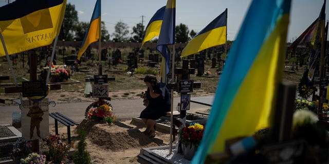 woman cries at her son's grave 