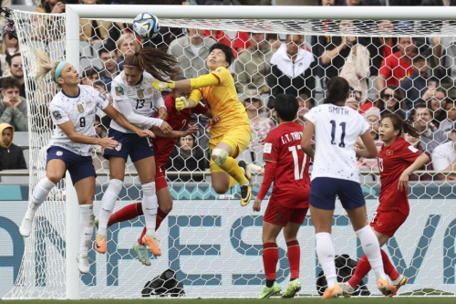 Players collide in the box as Vietnam goalkeeper Trần Thị Kim Thanh looks to clear the ball away.