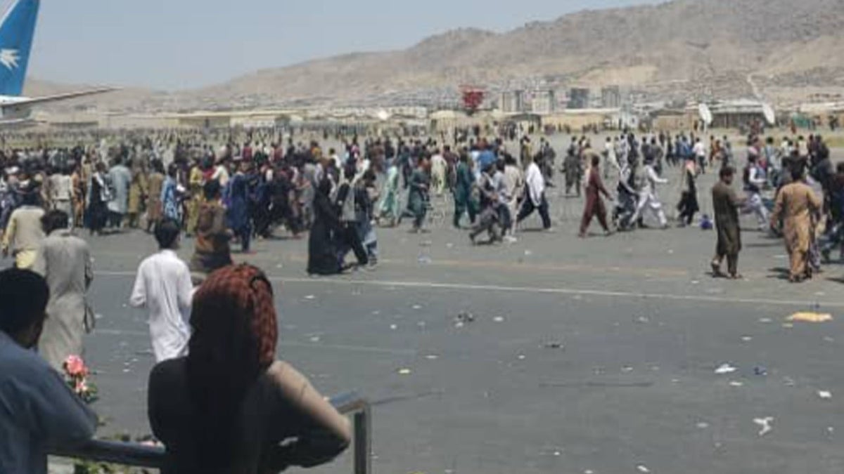 Afghans flood the tarmac of the airport