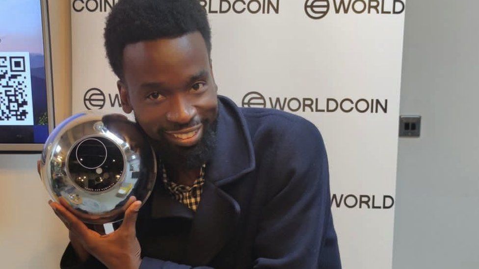 Moses Serumaga with a Worldcoin orb