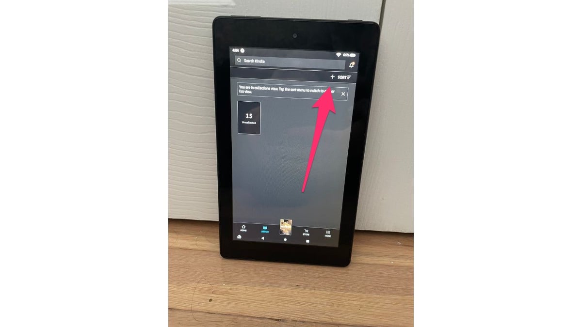 Red arrow pointing to the + (plus) icon on Amazon Kindle