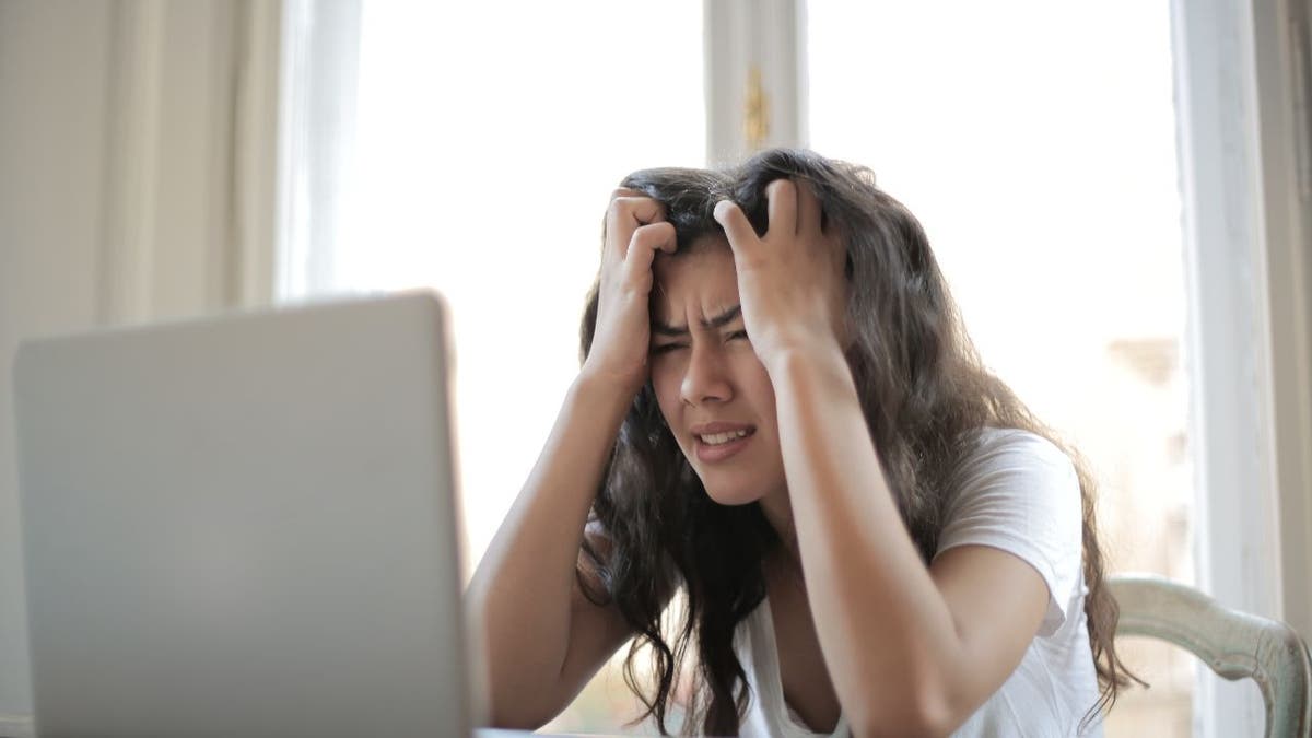 Woman stressed out at her laptop.