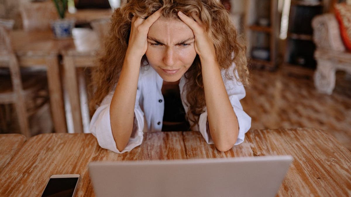 Upset woman looking at her computer.