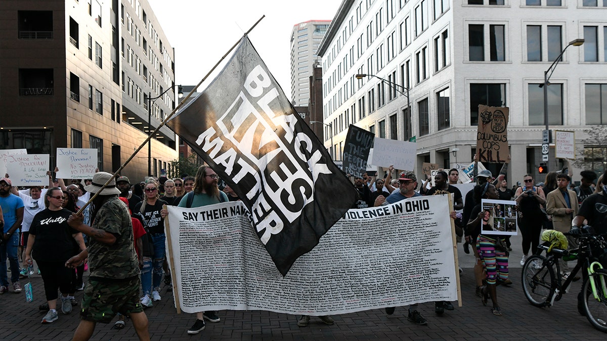 Protesters, a BLM flag