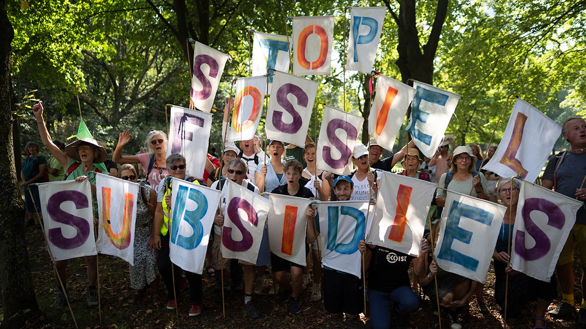 Protesters hold letter signs that spell, "stop Fossil Subsidies"