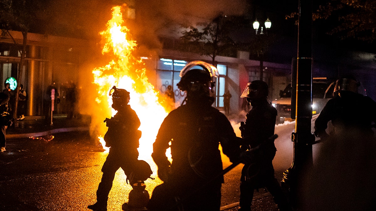 Portland police seen near a fire during Portland's summer of riots and protests in 2020