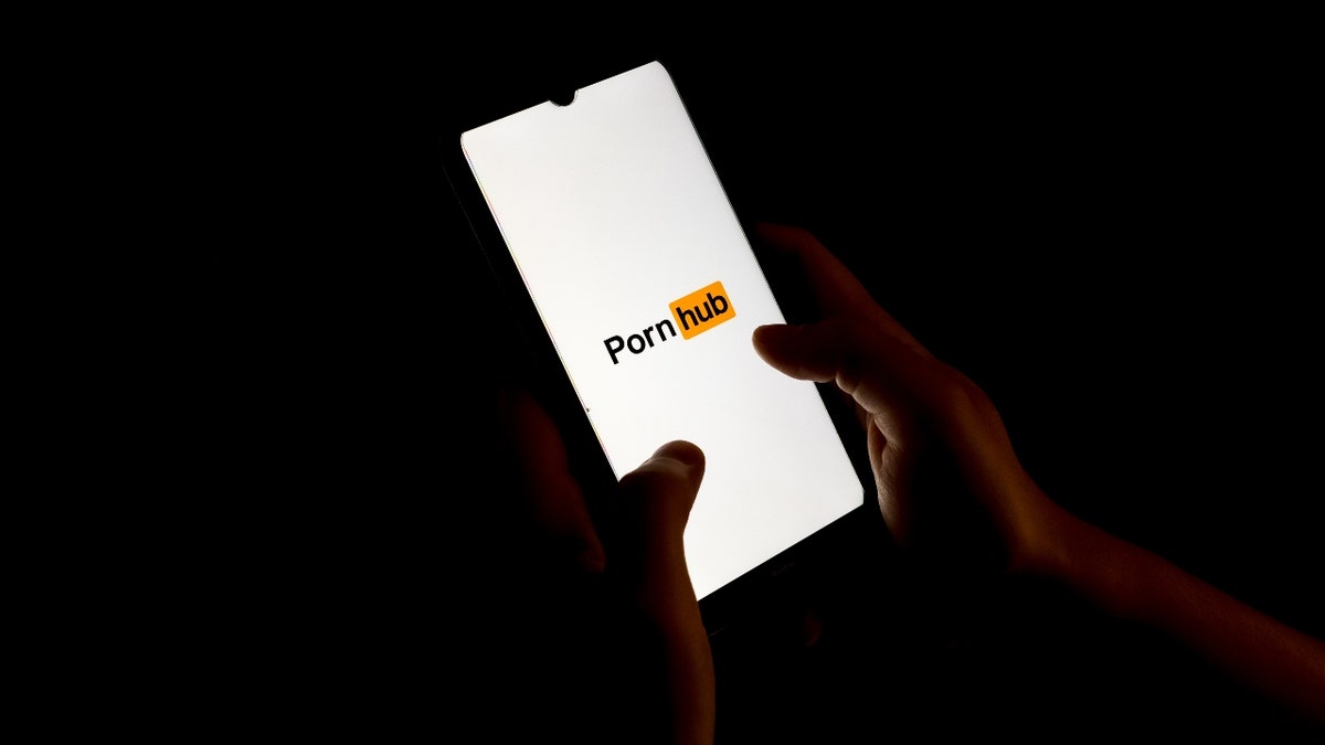 The PornHub logo appears on a smartphone
