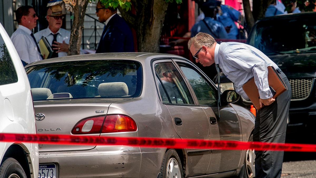 Philadelphia police inspect scene where driver was shot in car