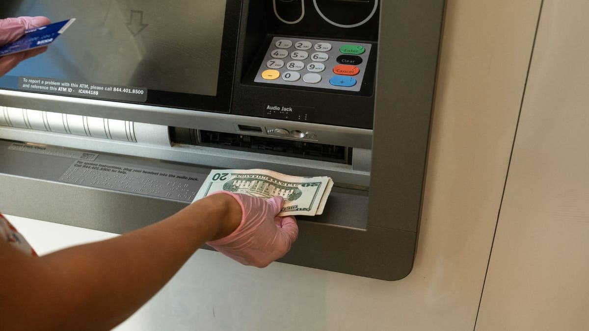 Woman taking cash from an ATM.