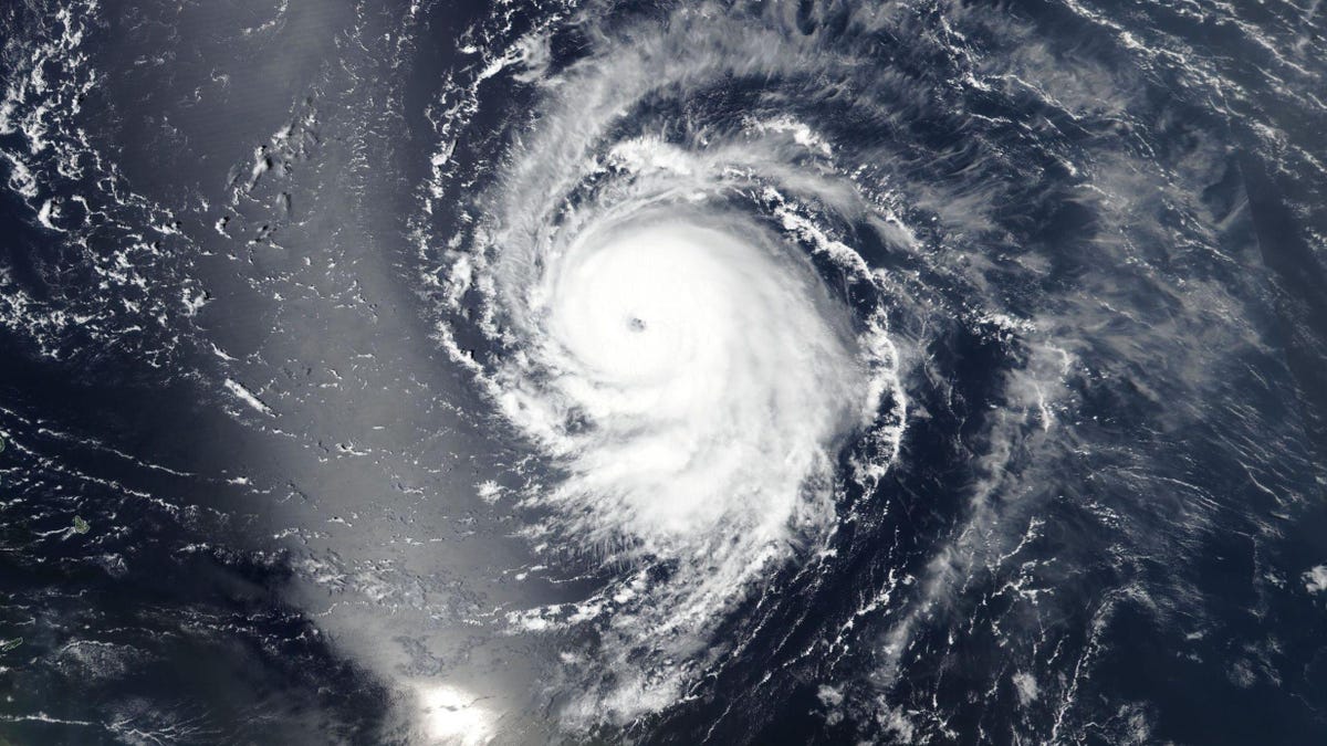 Satellite view shows large, round Hurricane Lee as white swirling clouds over a dark ocean.