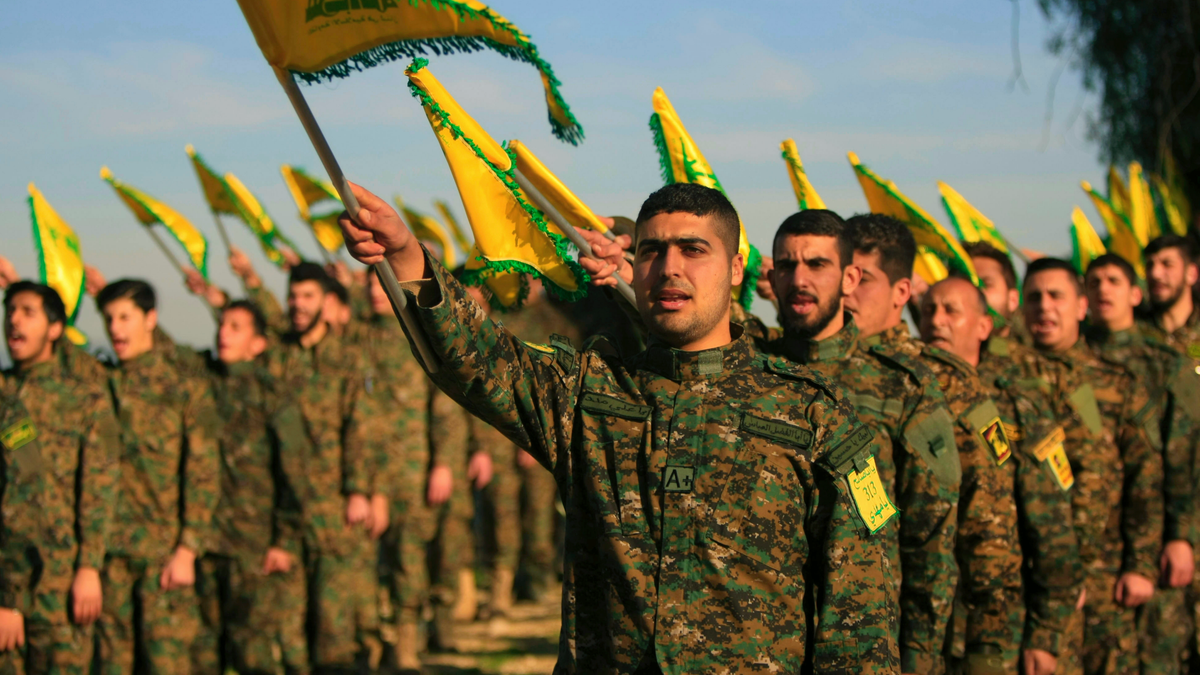 Hezbollah fighters hold flags