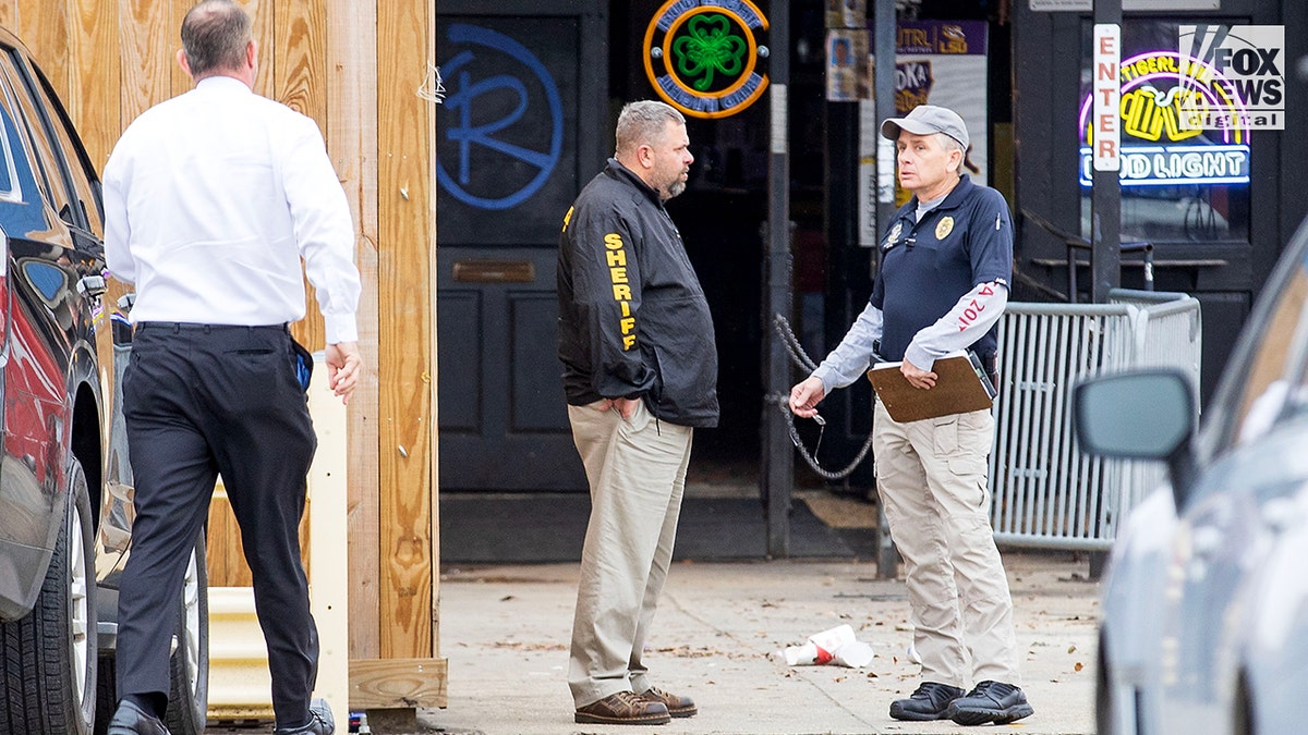 An exterior view of Reggie's with investigators standing outside