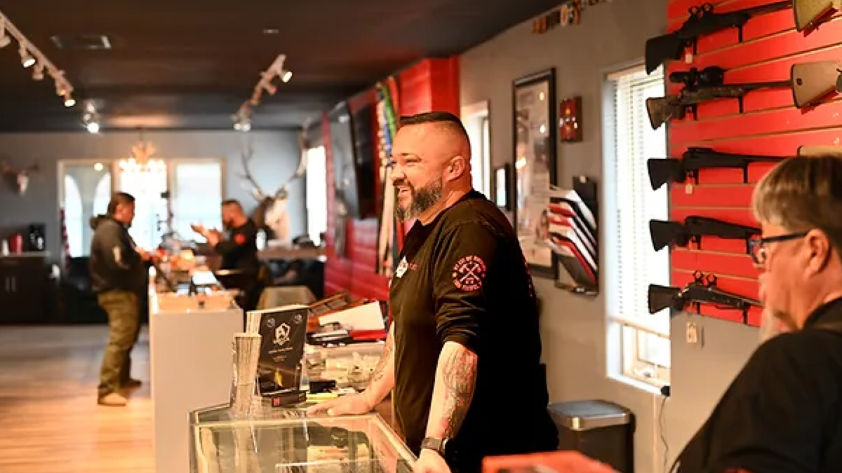 Joe Talachy behind counter at his gun store
