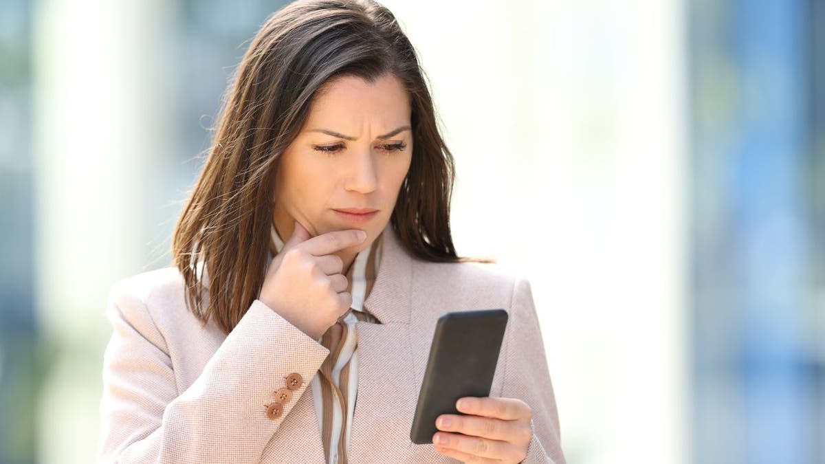 Confused woman looking at her phone