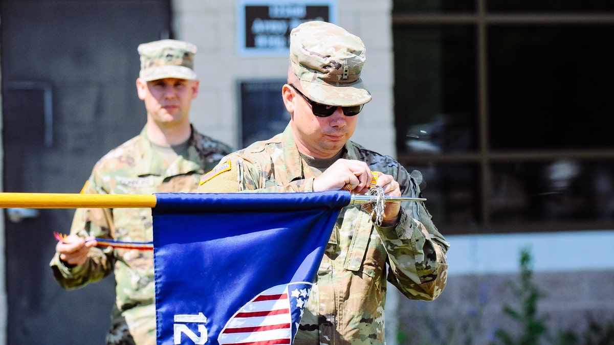 Soldier adds streamer to guidon